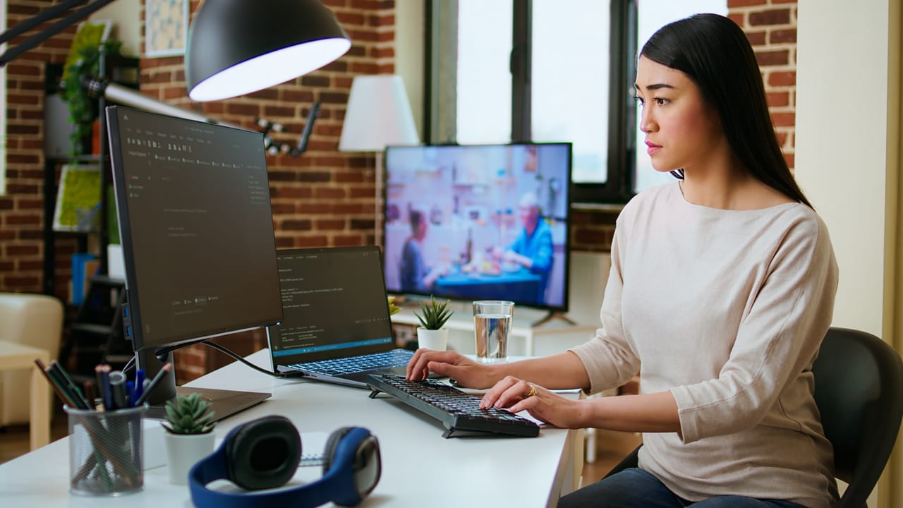 Software developer writing React and TypeScript code at a modern workstation